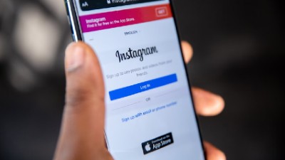 Handphone berisi aplikasi instagram dipegang oleh seseorang